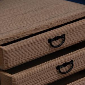 こげ茶色の木目の桐箱の引き出し部分をアップで映した写真