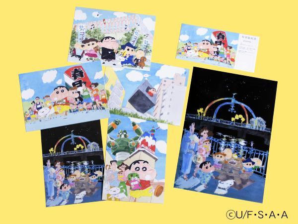 クレヨンしんちゃんのキャラクターと春日部の風景が描かれた、絵ハガキなどのグッズが並んでいる写真