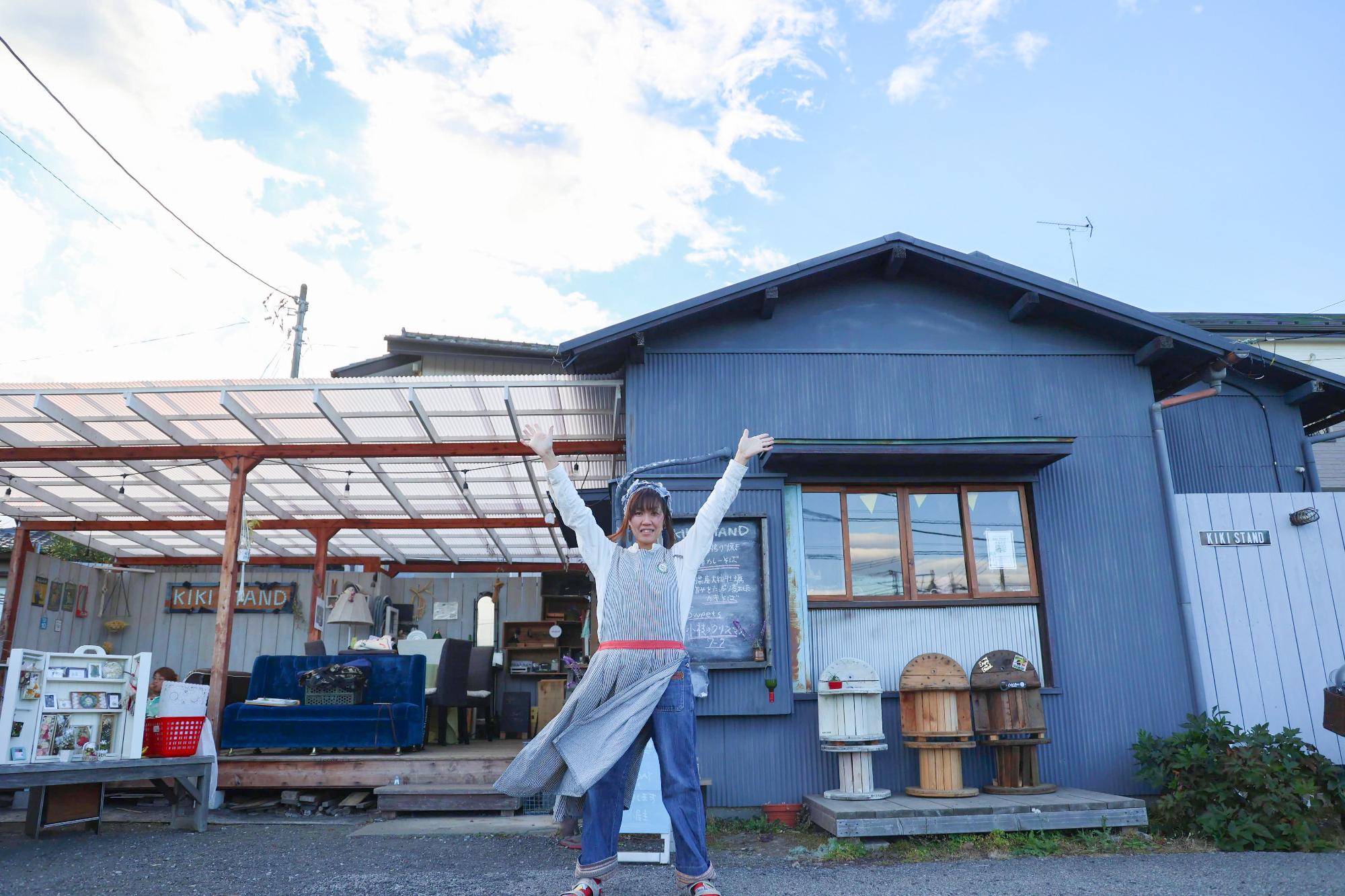 KIKISTANDの前で手を挙げるTAKAYOさん