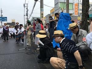 道の脇でしゃがみこむ運営スタッフたちの写真