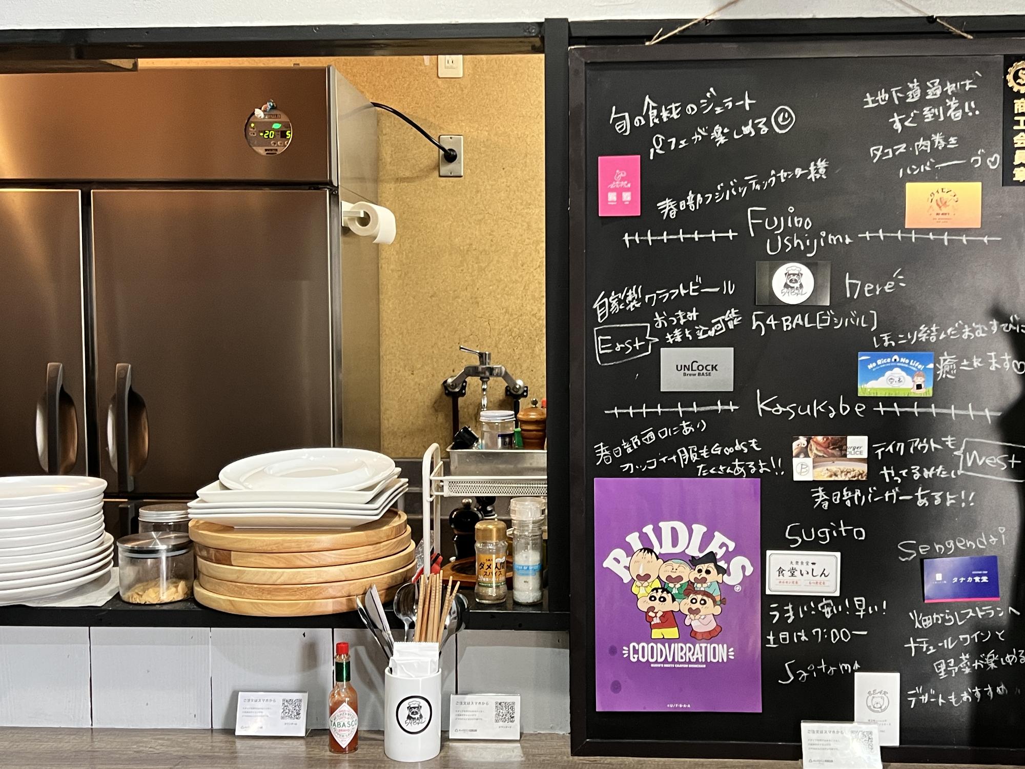 カウンター席の端にある黒板に、近隣のお店の情報などが掲載されている様子
