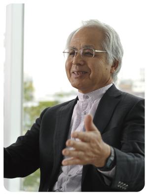 黒いジャケットを羽織り、両手をひろげて笑顔を見せる増村 紀一郎さんの写真