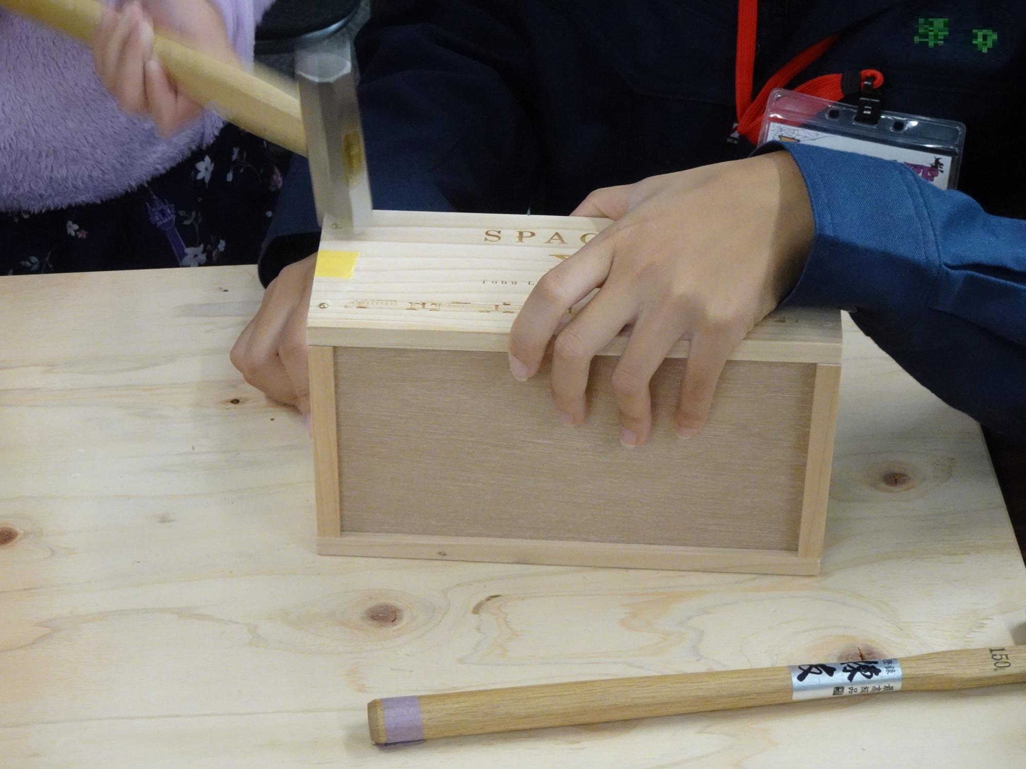 金槌を使って桐箱の組み立て体験をしている様子