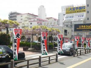 様々な建物が並ぶ春日部駅西口の前に、大凧あげ祭りののぼりが並んでいる写真