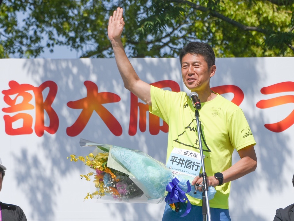 プレゼンターとして壇上に上がる平井大使