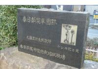 説明文の横に植物のようなものの絵が掘られている、国立薬用植物栽培試験場跡の石碑の写真