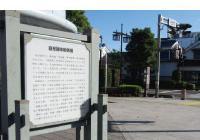 歩道の道端に、粕壁宿の案内板が立っている写真