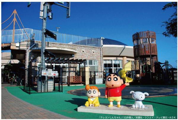 クレヨンしんちゃんのしんのすけ、ひまわり、シロのモニュメントが広場に並んでいる写真