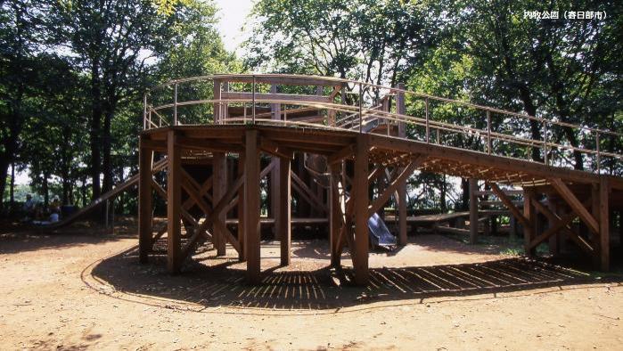 公園内に設置された木目調の遊具を横から撮影した写真