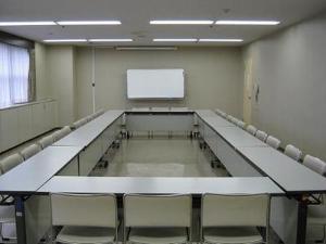 長机と椅子がロの字型になり、奥にホワイトボードのある小会議室の写真