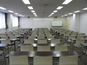 長机と椅子が並んだ、奥にホワイトボードのある中会議室の写真