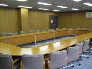 肘掛け椅子と机がロの字型になった中会議室の写真