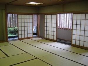 障子が開いていて木が見えている畳張りの和室の写真