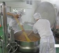 調理員2人でライスボイラーの中身を混ぜる