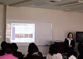 プロジェクターを使い解説を行う講師の女性の写真