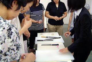 まな板と包丁を使った洗浄消毒の実務研修を行う様子の写真