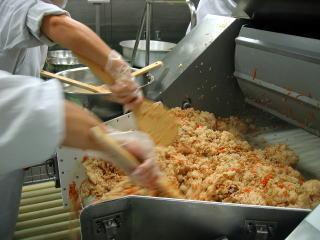 しゃもじを持って混ぜご飯を作っている様子の写真