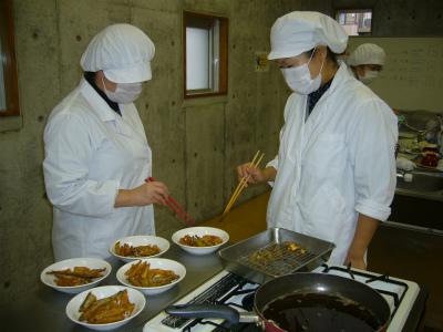 出来上がった魚のフライのチェックをしている調理実技研修の写真