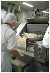 軽量しながらバット缶にご飯を入れている様子の写真