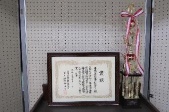 令和3年度受賞のトロフィーと、額に入った賞状の写真
