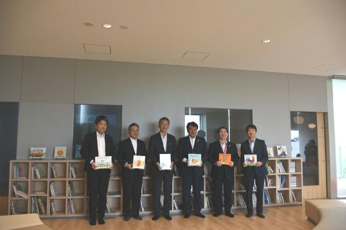 市役所コミュニティ棟2階かすかべっ子ルームにて寄贈された絵本を手に持って撮影した写真