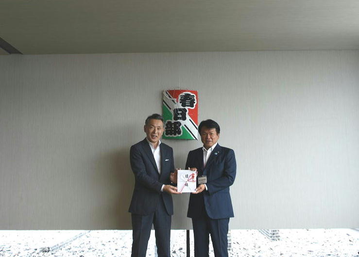 株式会社図書館流通センターの菅野社長から岩谷市長に寄贈絵本の目録が贈呈される写真