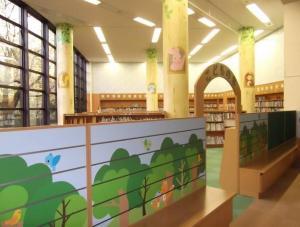 動物や木のイラストが描かれた児童開架室の写真