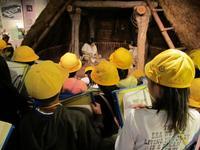 竪穴式住居を見学する小学校の見学風景の写真