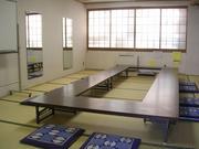 側面の壁に鏡が備え付けられている武里南地区公民館和室（机と座布団を置いた状態）の写真