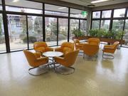 全面がガラス張りになっていて開放的な雰囲気の粕壁南公民館展示ロビー兼談話コーナーの写真