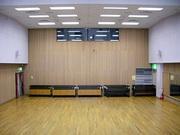 温かい風合いの木製の壁と床が特徴的な内牧地区公民館講堂の写真