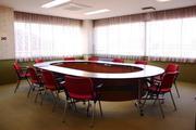 楕円枠の机に赤い椅子が並べられている豊野地区公民館会議室の写真