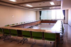 長方形の枠型に並んだ長机と緑色のパイプ椅子のある豊野地区公民館研修室2の写真