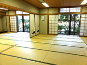 縁側から庭の緑が眺められる内牧地区公民館和室の写真