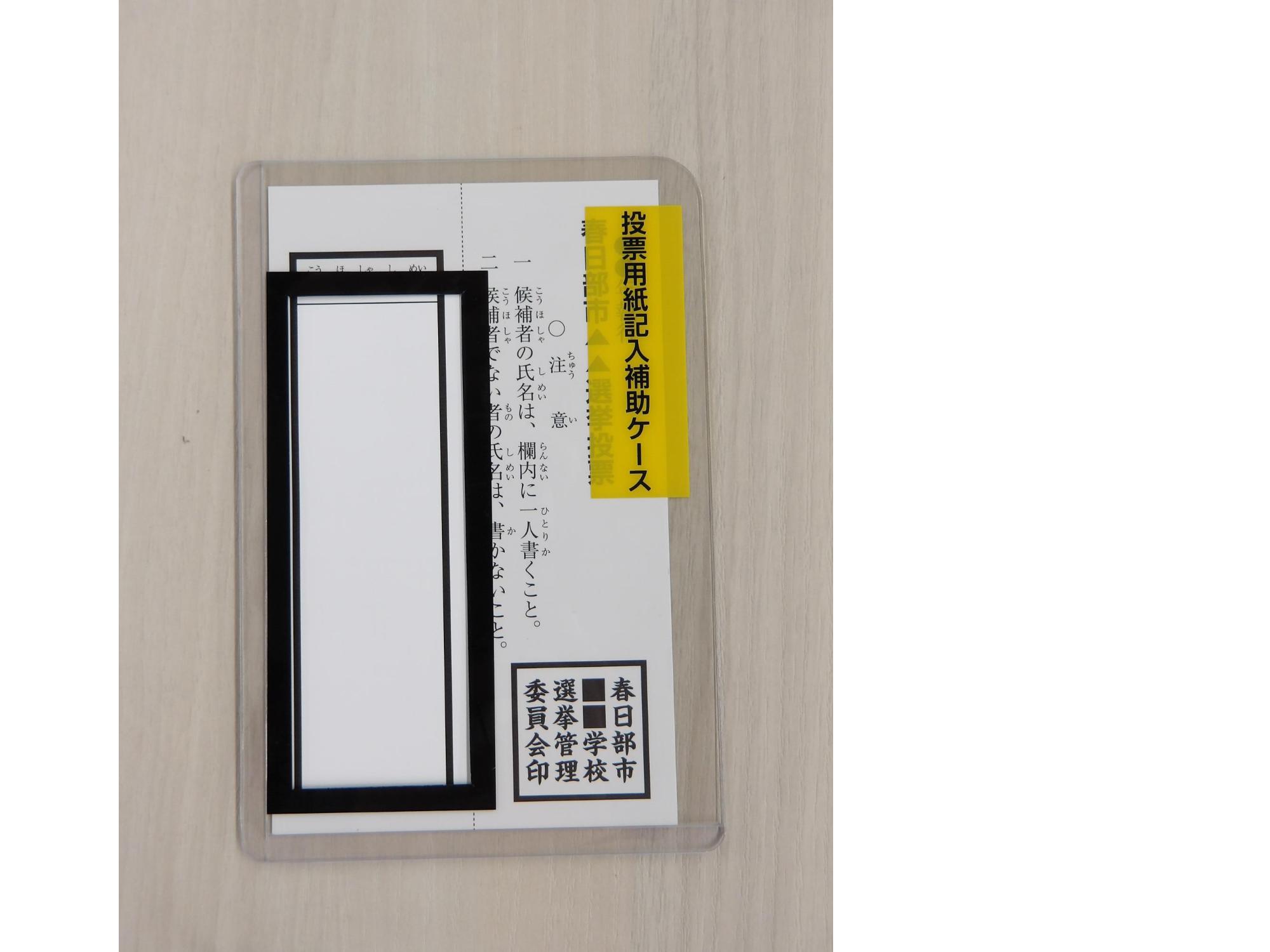 投票用紙記入補助具に投票用紙をはさんだイメージ図