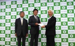 黒津審議会会長たちより答申を受け取る石川市長の写真