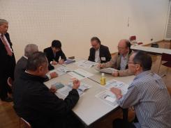 男性7名が新本庁舎の基本設計について懇談会で意見交換している様子の写真