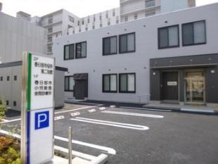 市立医療センター東側の駐車場入口付近より撮影された、春日部市小児救急夜間診療所の外観の写真